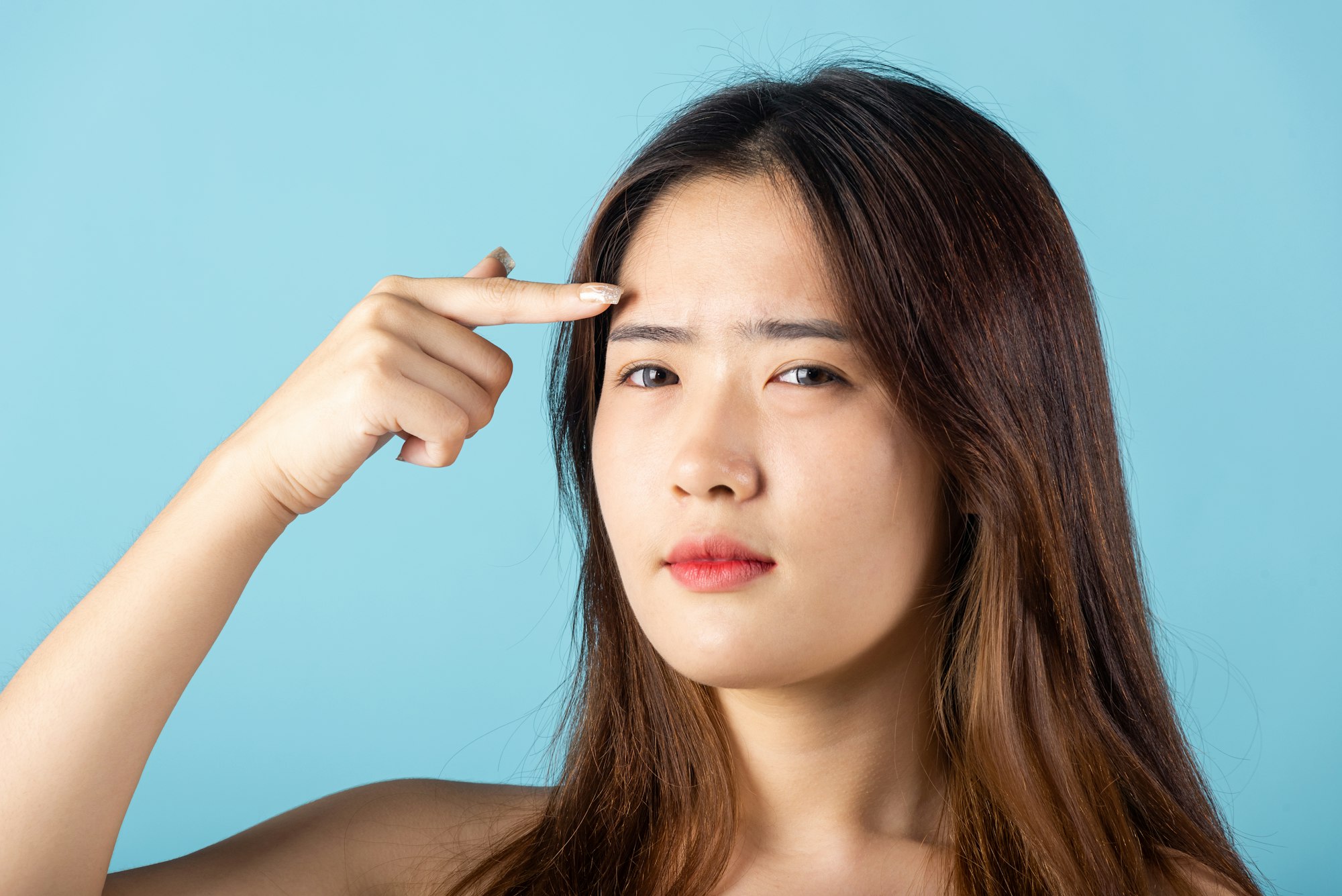 young woman pointing eyebrow with her finger